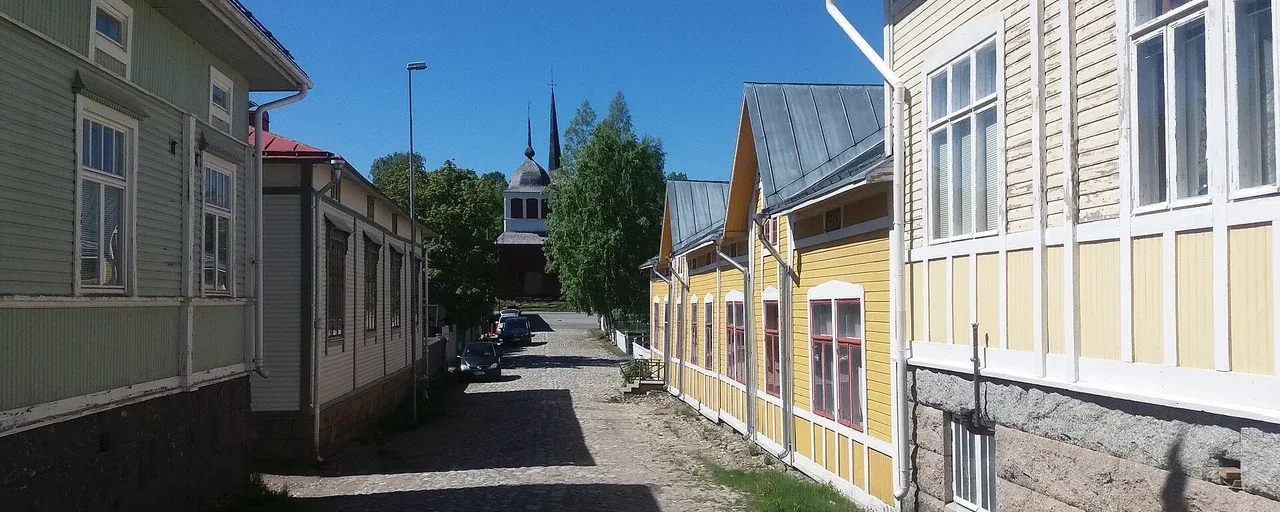 Puutaloja mukulakivikadun varrella kohti Ulrika Eleonoran kirkkoa Kristiinankaupungissa. Puutaloja mukulakivikadun varrella kohti Ulrika Eleonoran kirkkoa Kristiinankaupungissa.